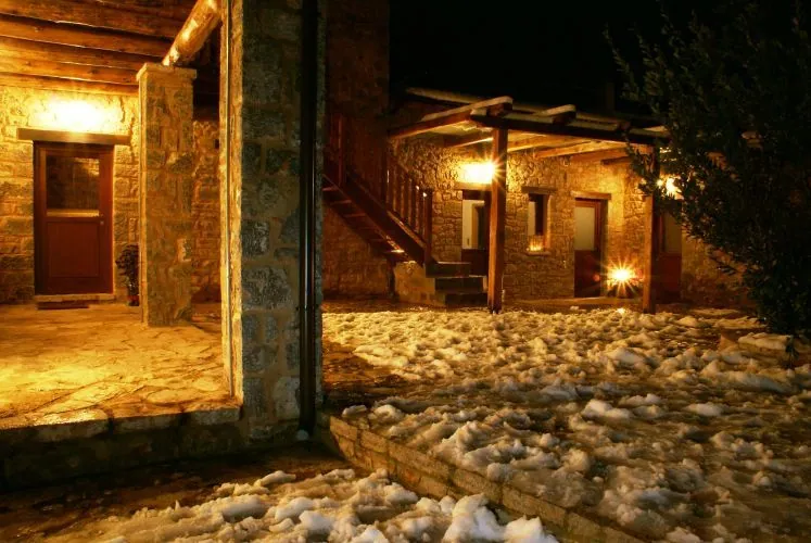 Η χιονισμένη αυλή του ξενώνα φωτισμένη τη νύχτα